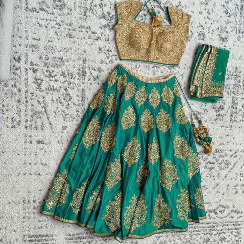 Iridescent green lehenga with a heavy golden blouse and dupatta